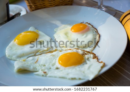 Image of plate with fried eggs at plate and cup of coffee,  breakfast in cafe