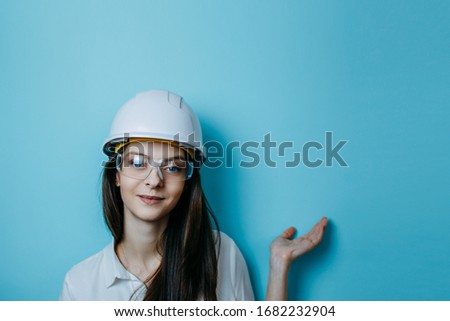 Woman engineer in white helmet and glasses, protective clothes., helmet and protective glasses.