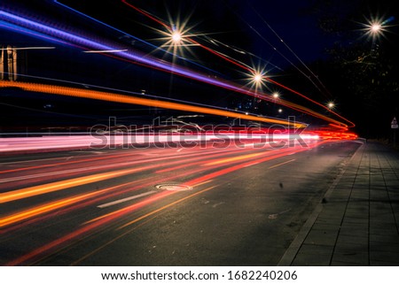 Night city life with long exposure of a riding bus in the street with colourful lights