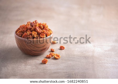 Dried physalis in wooden bowl on wood textured background. Copy space. Superfood, vegan, vegetarian food concept. Macro of inca berries, selective focus. Healthy snack.