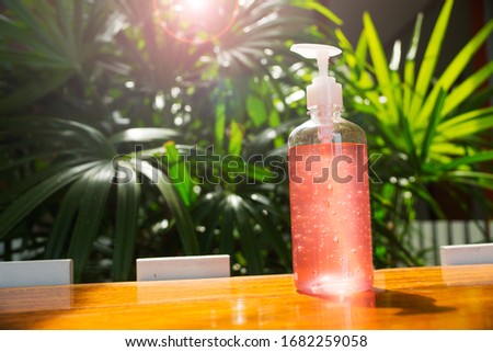 A bottle gel hand wash is laying on wooden table with nature background