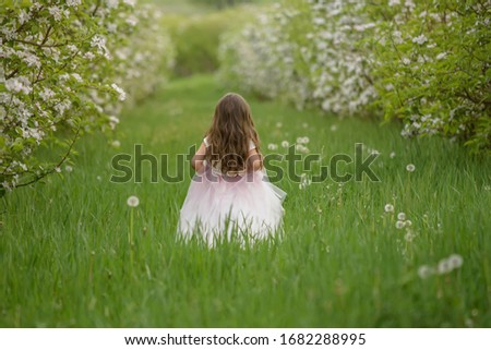 the girl in the flowered apple garden standing behind her