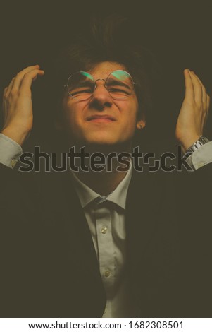 A man in glasses and a classic suit. The guy is in a state of depression. The guy is pensive. The guy in thoughts. Vintage photo processing.