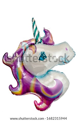 A balloon in the shape of a unicorn head filled with helium. Background for children's parties and birthdays.