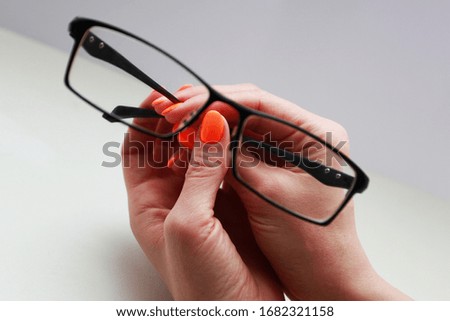 The female hand that holds the glasses
