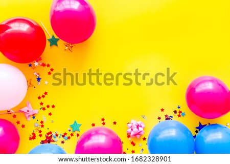 Decorative frame with colorful balloons on yellow background top-down frame copy space