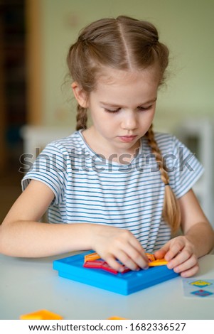 little girl solve the mathematical puzzle in the kindergarten class. close up