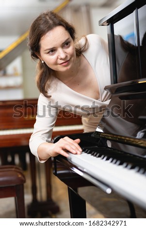 Young woman buys a piano in a music store