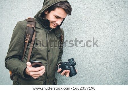Photographer transferring photos from digital camera to his phone using wifi connection
