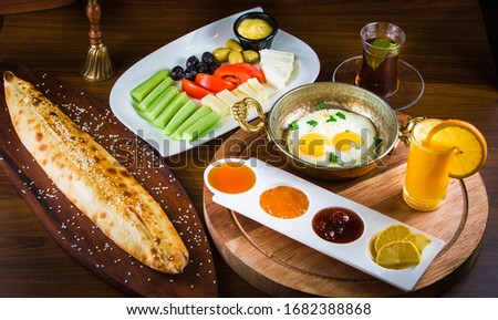 Traditional Turkish Breakfast with sesame bagel and fry egg with sausage.Used ceramic breakfast set and copper egg pan.