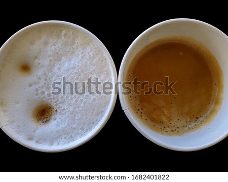 cappuccino and americano in disposable paper cups on a black background top view photo