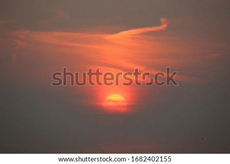 The sun behind the clouds at sunset