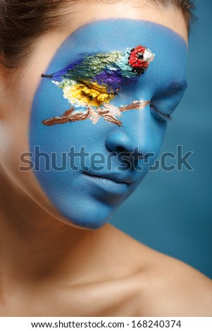 Beautiful fashion model with face art in winter style. Textural makeup.