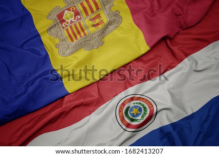 waving colorful flag of paraguay and national flag of andorra. macro