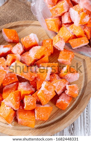 Frozen pumpkin on a cutting board. Vegetables containing carotene