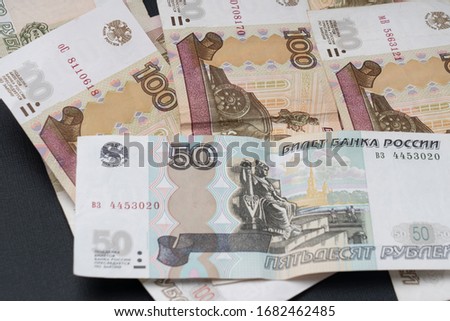 Russian hundred-ruble bills on a dark background, the concept of the Russian economy's recession, selective focus