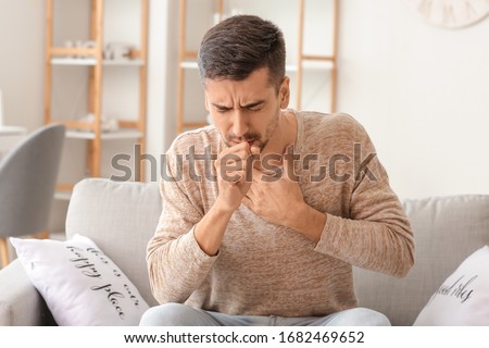 Coughing young man at home Royalty-Free Stock Photo #1682469652