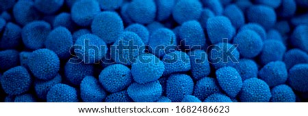 blue marmalade in the form of blackberries in a pile. lots of blue marmalade background texture screensaver chewy marmalade