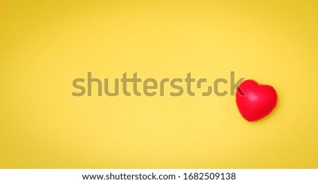 Red Heart on yellow paper card table top view background concept for Valentine day banner, mother day gift banner, happy birthday backdrop, greeting mom sweet care board, wedding romantic texture.