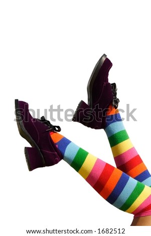 Happy Kicking Feet.  Striped knee-hi socks and wickedly wonky, purple suede shoes on isolated girl's legs.