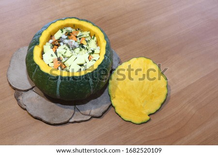 Raw green  pumpkin stuffed with vegetables on a standing on a table