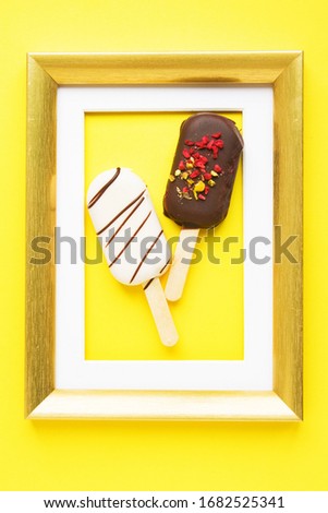 Dessert as Art. Brownie cake in form of popsicle in golden frame on yellow background.