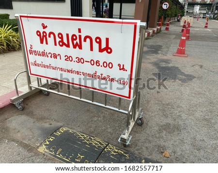 Thai sign is written about don’t pass this way from 8.30pm to 6 am for prevention of covid 19