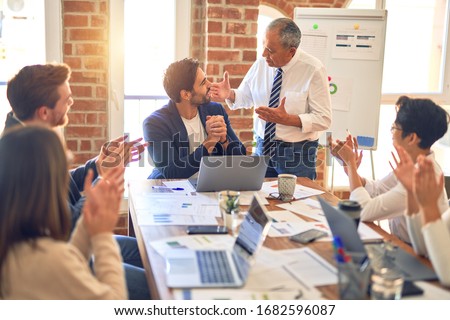 Group of business workers smiling happy and confident. Working together with smile on face applauding one of them at the office Royalty-Free Stock Photo #1682596087