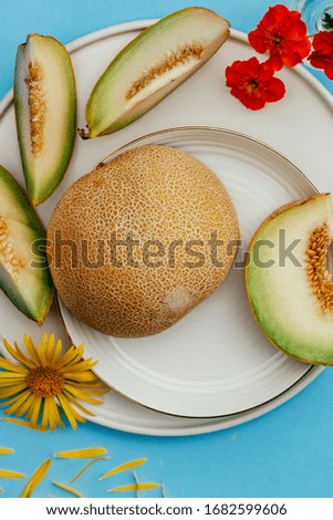Ripe whole melon and sliced ​​into slices on a blue background. Food photo for food store.