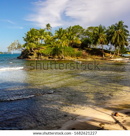 The tropical environment of a beautiful and colourful island with white sand beaches, turquoise clear water and jungle greenery of Panamanian archipelago in the Caribbean sea during a sunny day. 