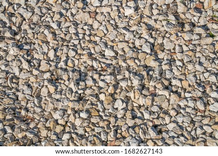 Gravel  background. Floor, road building construction site. Small pebbles of mineral. Closeup picture. rock surface texture for background, desktop, etc. Wallpaper background. Closeup shot. Grey,sunny