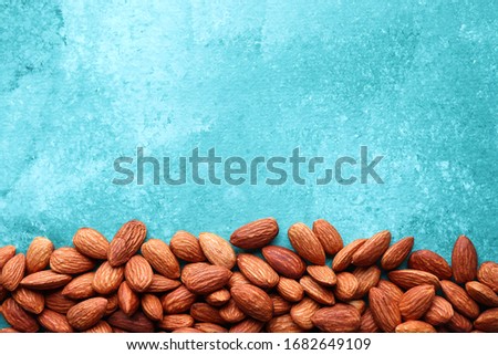 colorful photo of almonds on a turquoise background, top view, place for text