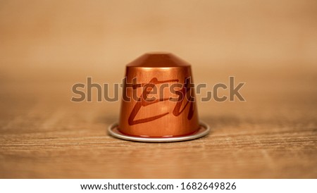 orange coffee capsule with writing