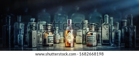 A bottle of poison on a background of old medical, chemistry and pharmacy glass. Chemistry and pharmacy history panoramic concept background. Retro style. Royalty-Free Stock Photo #1682668198