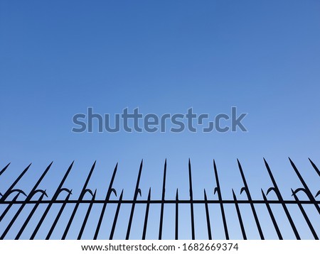 Anti theft steel. anti climb security rollers with barbed spikes. Wall security bars for house safety. Brutality architecture design to protect burglar or intruder. Cloud and sky background.