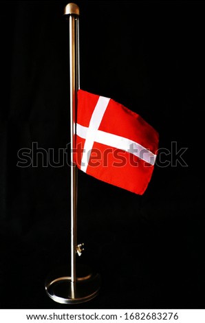 Small Danish flag at half-mast and a black background symbolising the loss of a loved one