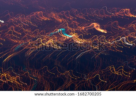 Free drawing in lightpainting phytography. Neon light trails or lines creating an abstract effect. Full of life and very soft. wavy dance of lines on a dark background. fluid streaks of lights. magic