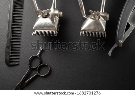 black surface are old hairdresser tools. black monochrome. horizontal orientation. top view, flat lay