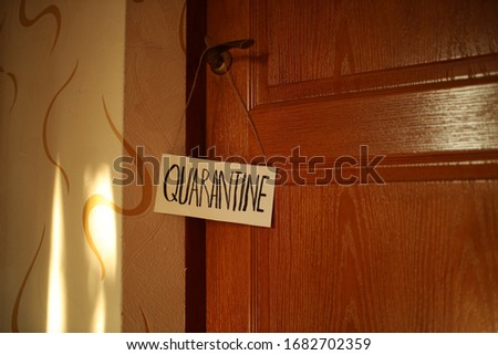 Quarantine plate on a wooden door. The inscription quarantine. Quarantine. Insulation. Self isolation.