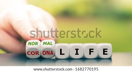 Back to normal. Hand turns dice and changes the expression "corona life" to "normal life". Royalty-Free Stock Photo #1682770195