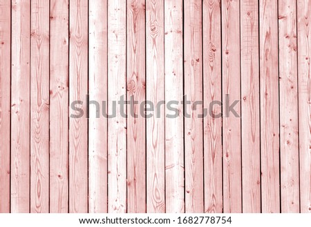 Fence made of wooden planks in red tone. Abstract background and texture for design.