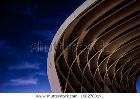 Abstract curved crossed and futuristic stripes and lines shape like a wave with dark blue sky in the background  Royalty-Free Stock Photo #1682783191