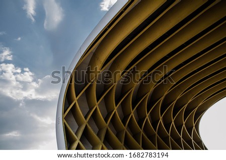 Abstract curved crossed and futuristic stripes and lines shape like a wave with bright sky in the background  Royalty-Free Stock Photo #1682783194