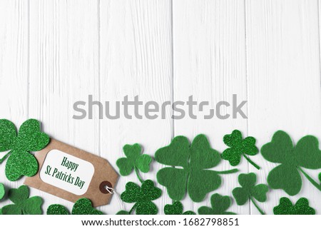 Flat lay composition with clover leaves on white wooden table, space for text. St. Patrick's Day celebration