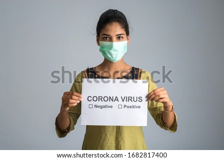 A young woman or girl in a medical mask holding a board of the epidemic of Coronavirus, Covid-19