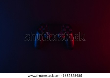 Gamepad on black backround with pink blue neon light. Gaming concept.