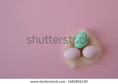 Eggs in nest on pink background. Concept of minimalism

