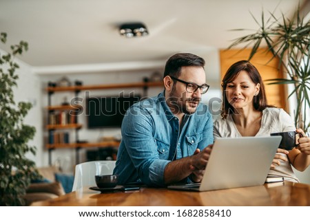 Portrait of a casual business people looking at laptop at workplace. Royalty-Free Stock Photo #1682858410