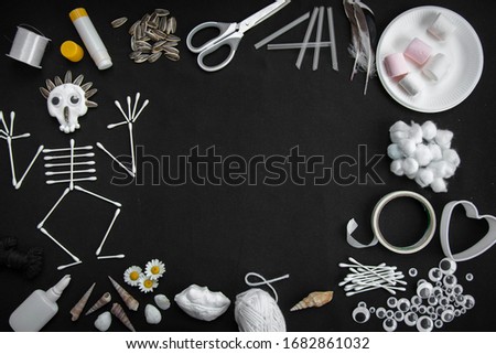 kids art skeleton picture on a black fabric background with different stationary materials 
