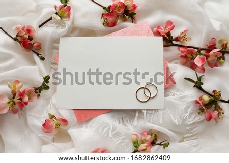 Wedding invitation design. wedding ring and flowers on a white silk background. congratulation. invitation